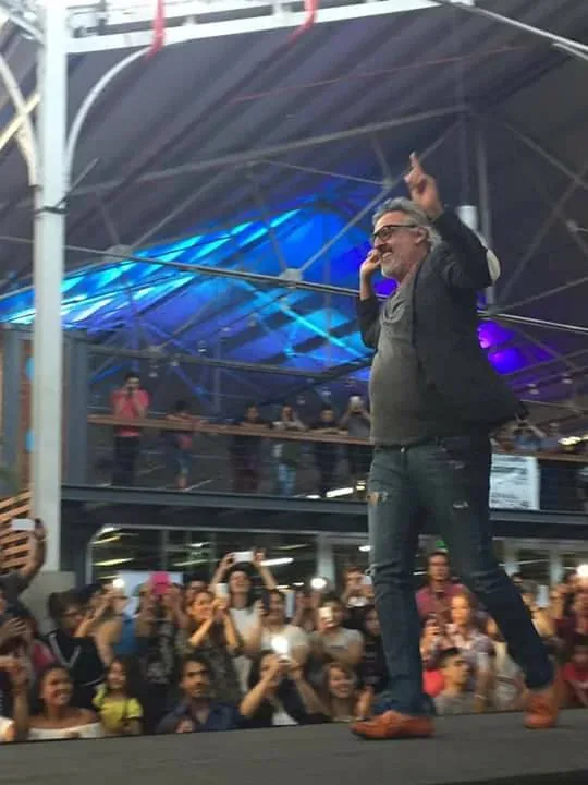 Un presentador se dirige al público desde el escenario.
